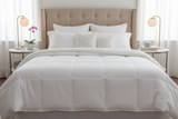 White comforter on a bed with pillows and nightstands in a bedroom setting