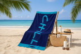 Blue beach towel with 'CHILL' text on a wooden chair at the beach.