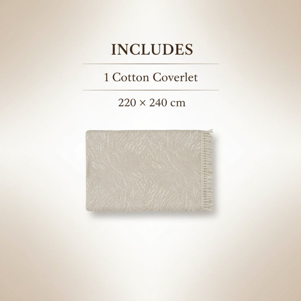 Neatly made bed with beige bedding in a bedroom setting.