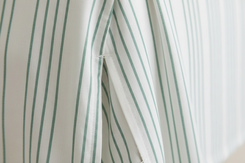 Close-up of a white curtain with green stripes