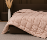 Hotel-quality cotton feather filled comforter from the Signature Collection styled in a luxury bedroom with soft layered bedding and elegant neutral décor