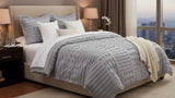 Neatly made bed with decorative pillows and a coverlet in a bedroom setting.